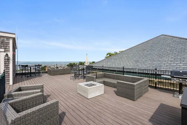 a roof deck with couches and wooden floor