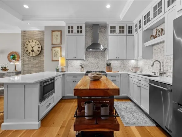 a kitchen with stainless steel appliances granite countertop a stove a sink and a microwave