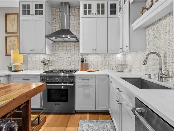 a kitchen with a stove sink and cabinets
