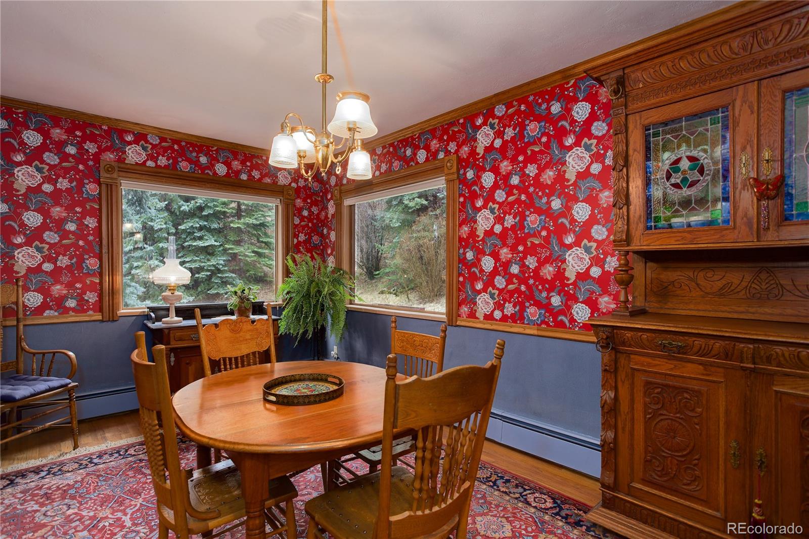 1730 Upper Bear Creek Road Evergreen, CO 80439 - Photo 19 of 40 a dining room with furniture a rug a potted plant and a chandelier
