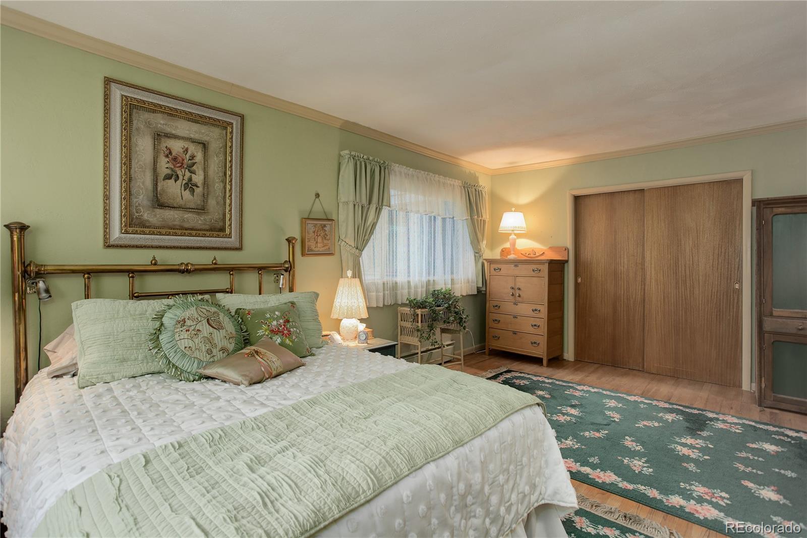 1730 Upper Bear Creek Road Evergreen, CO 80439 - Photo 25 of 40 a bedroom with a large bed and a chandelier