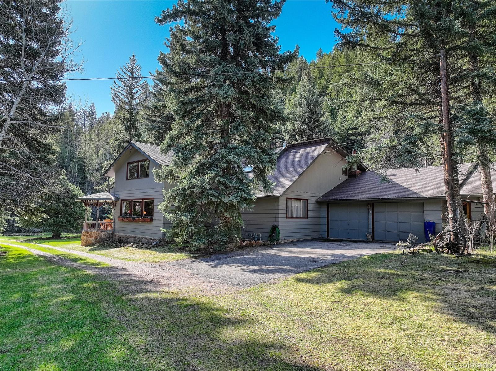 1730 Upper Bear Creek Road Evergreen, CO 80439 - Photo 35 of 40 a house with a large tree in front of it