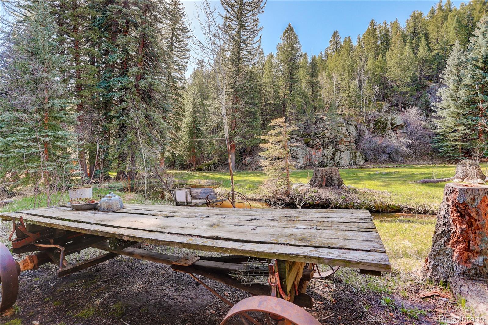1730 Upper Bear Creek Road Evergreen, CO 80439 - Photo 36 of 40 a view of a wooden chairs and fire pit in the backyard