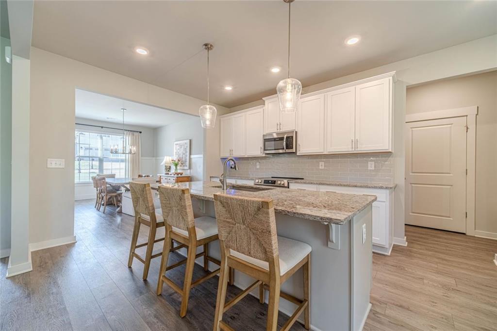 4070 Links Boulevard Jefferson, GA 30549 - Photo 14 of 46 a kitchen with stainless steel appliances granite countertop a kitchen island hardwood floor and a sink
