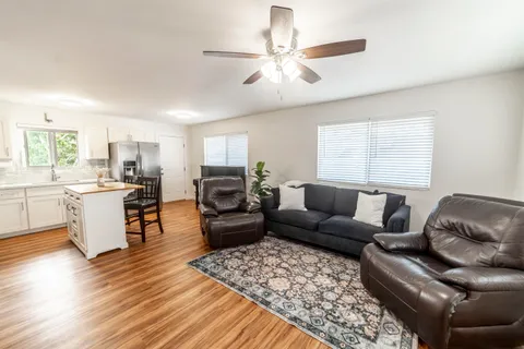 a living room with furniture ceiling fan and a window
