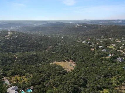 an aerial view of house with yard and mountain view in back