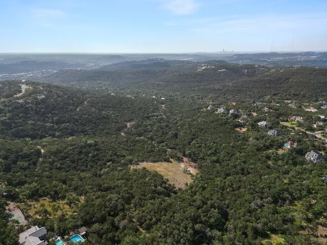 an aerial view of house with yard and mountain view in back