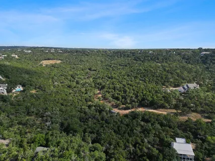 an aerial view of residential houses with outdoor space and trees