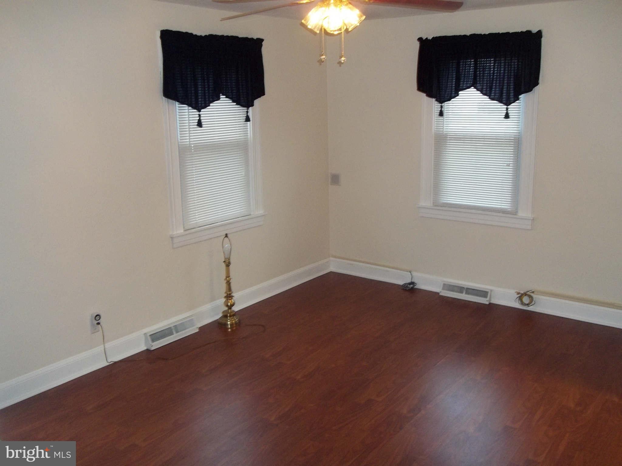 30 Crafton Road Baltimore, MD 21221 - Photo 7 of 17 an empty room with wooden floor and windows
