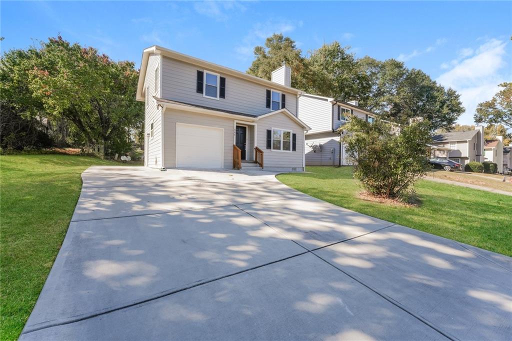 884 3rd Street Stone Mountain, GA 30083 - Photo 12 of 26 a front view of a house with a yard and garage