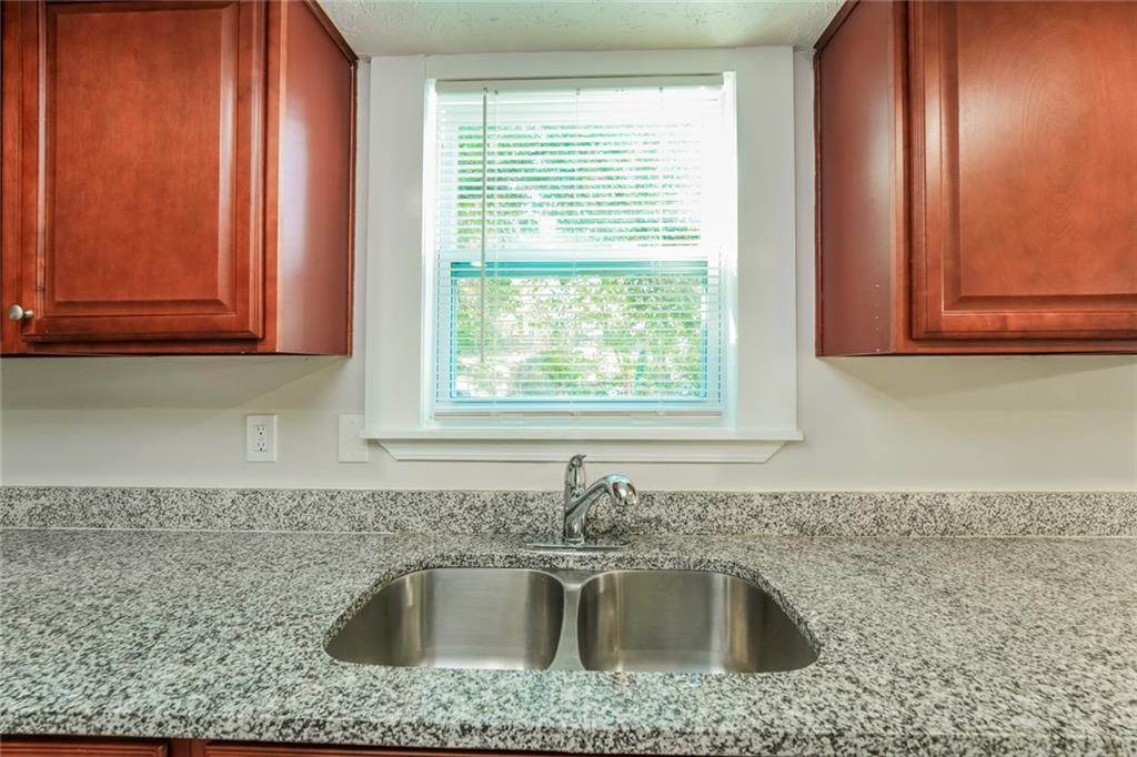 884 3rd Street Stone Mountain, GA 30083 - Photo 15 of 26 a kitchen with granite countertop a sink window and cabinets