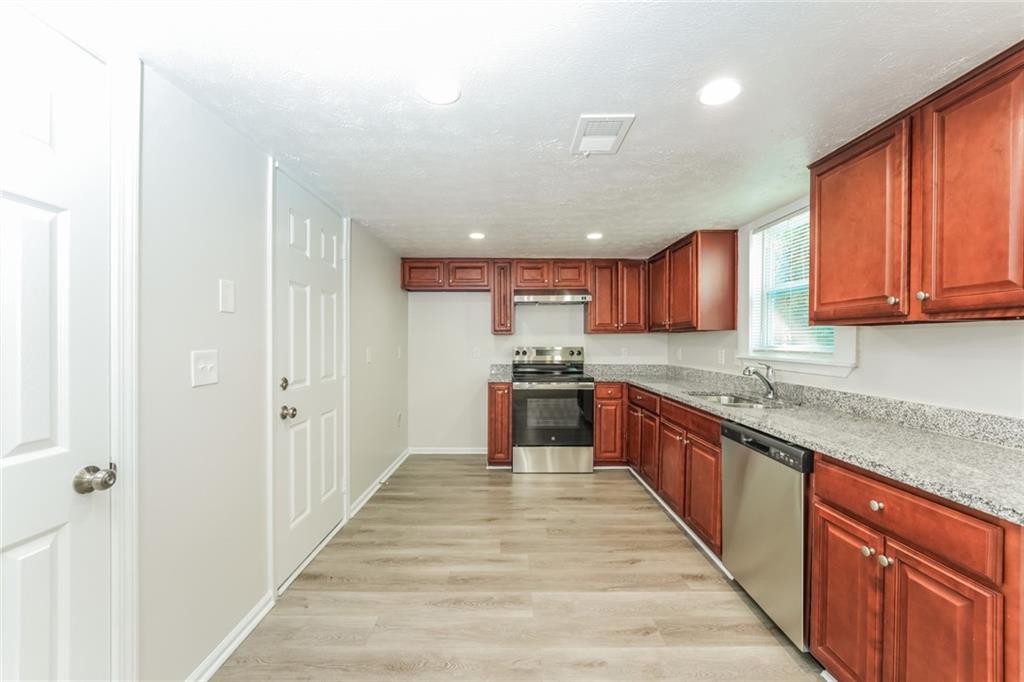 884 3rd Street Stone Mountain, GA 30083 - Photo 2 of 26 a large kitchen with stainless steel appliances granite countertop a large counter top a sink and a refrigerator