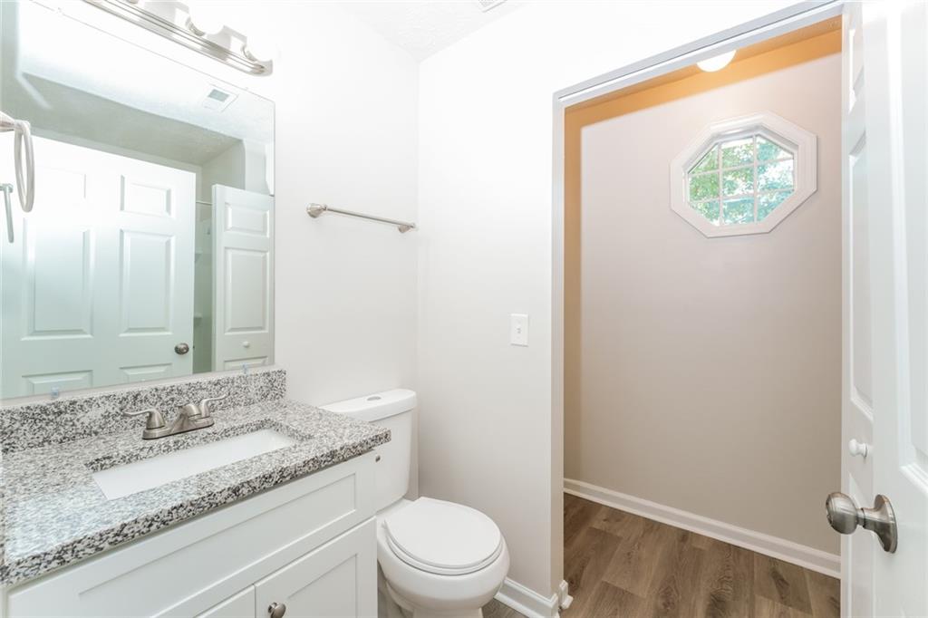 884 3rd Street Stone Mountain, GA 30083 - Photo 4 of 26 a bathroom with a granite countertop sink and a mirror
