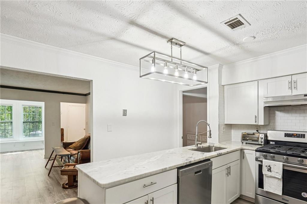 2071 Brian Way Decatur, GA 30033 - Photo 15 of 28 a kitchen with a sink dishwasher a stove and a chandelier