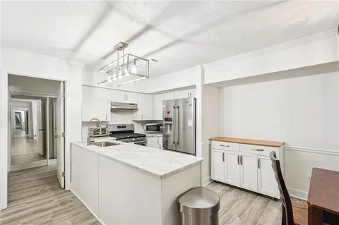 a kitchen that has a lot of cabinets a sink and dishwasher