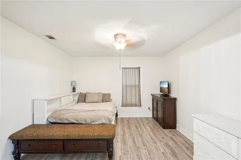 a bedroom with a bed and wooden floor