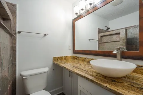 a bathroom with a granite countertop sink and a mirror
