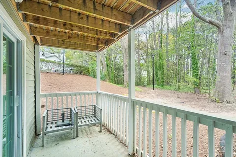 a porch with a bench next to a yard