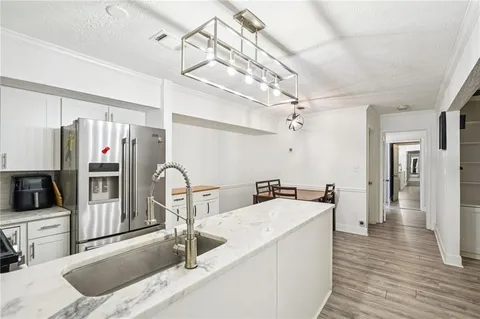 a kitchen with stainless steel appliances granite countertop a sink and a refrigerator