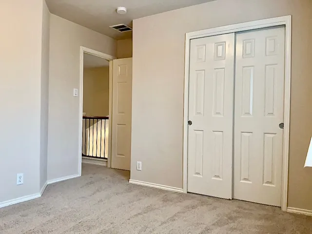 an empty room with closet and a bathroom