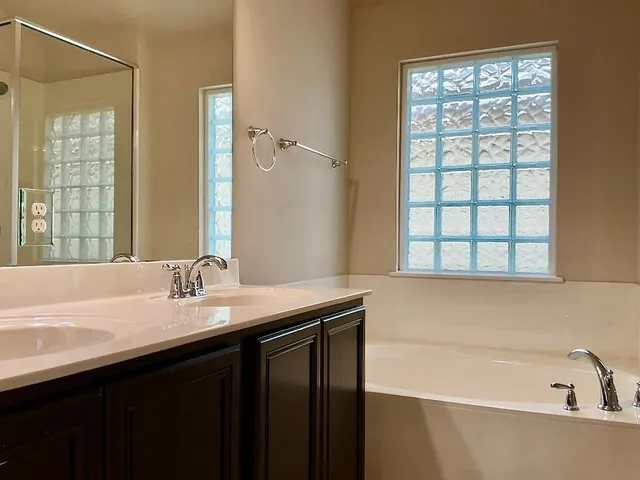 a bathroom with a granite countertop sink and a bathtub