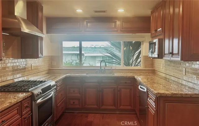 a kitchen with kitchen island granite countertop a stove and a sink