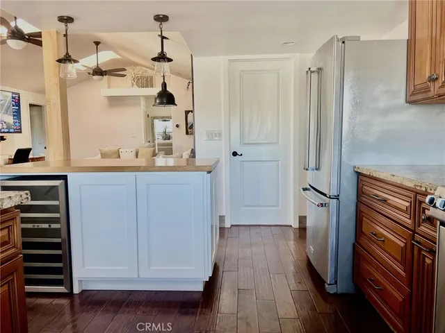 a kitchen view with wooden floor and electronic appliances