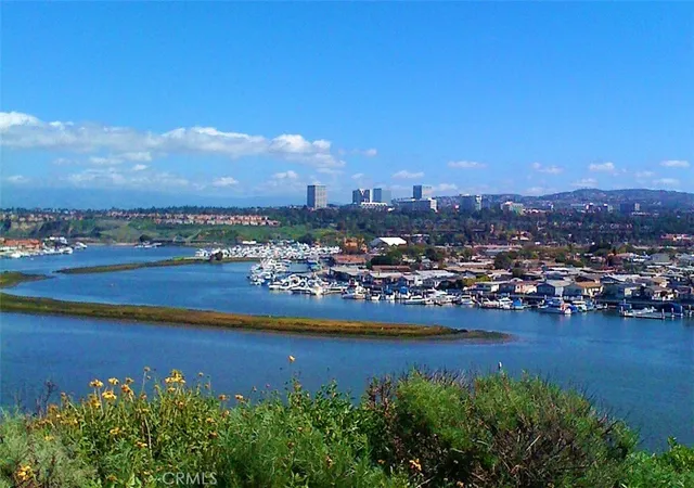 a view of a city with lots of residential buildings ocean and mountain view in back