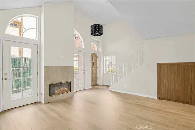an empty room with windows cabinet and fireplace