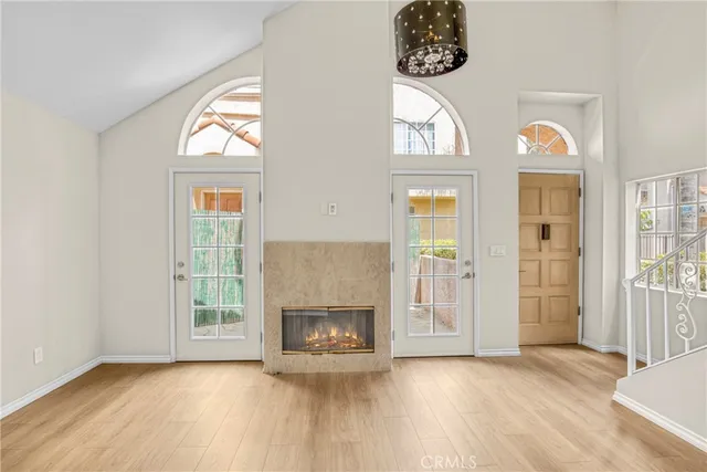 an empty room with wooden floor a fireplace and a window