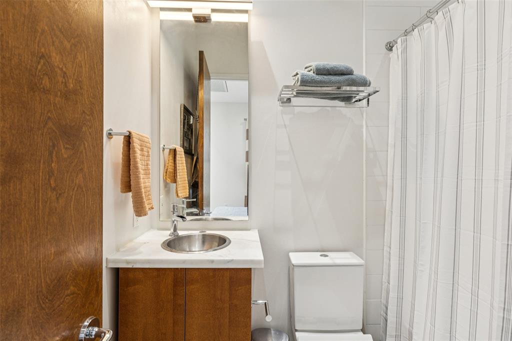 4420 Holland Avenue, Unit A Dallas, TX 75219 - Photo 22 of 32 a bathroom with a sink a toilet and mirror