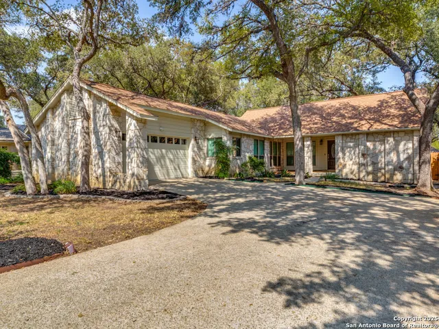 a front view of a house with a tree