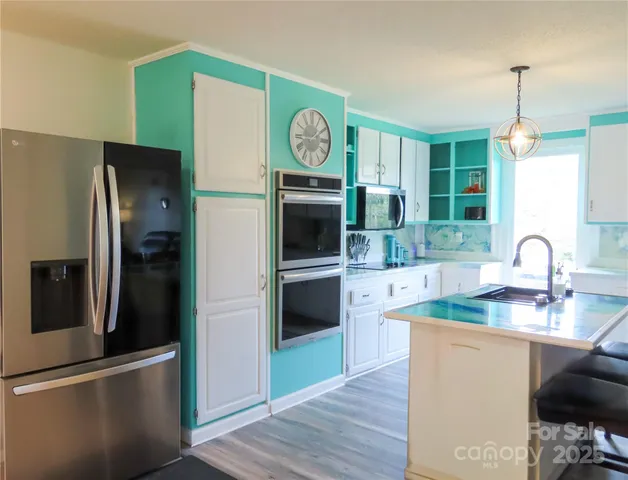 a kitchen with stainless steel appliances granite countertop a refrigerator and a sink
