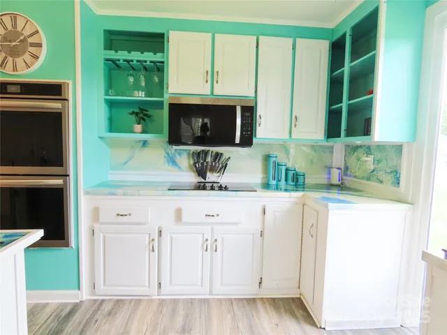 a kitchen with stainless steel appliances granite countertop a stove a sink and a microwave