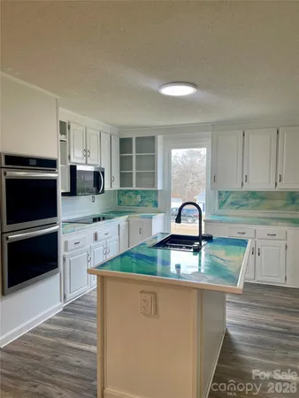 a kitchen with stainless steel appliances granite countertop a sink a microwave a refrigerator and cabinets