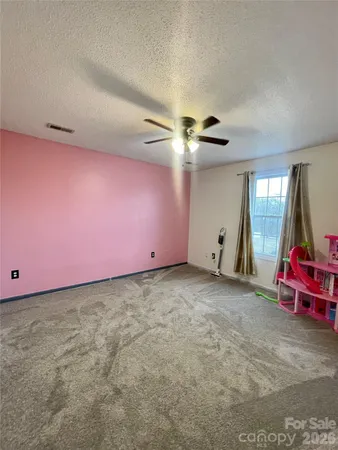 a view of wooden floor and a chandelier fan in a room