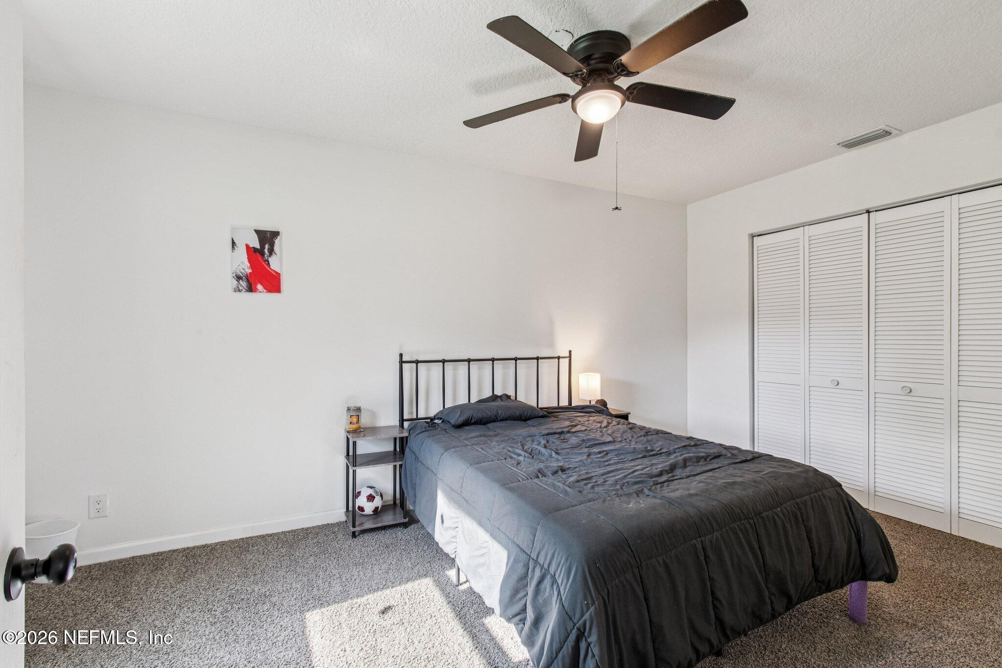 1417 Clock Street Jacksonville, FL 32211 - Photo 30 of 39 a bedroom with a bed and a chandelier