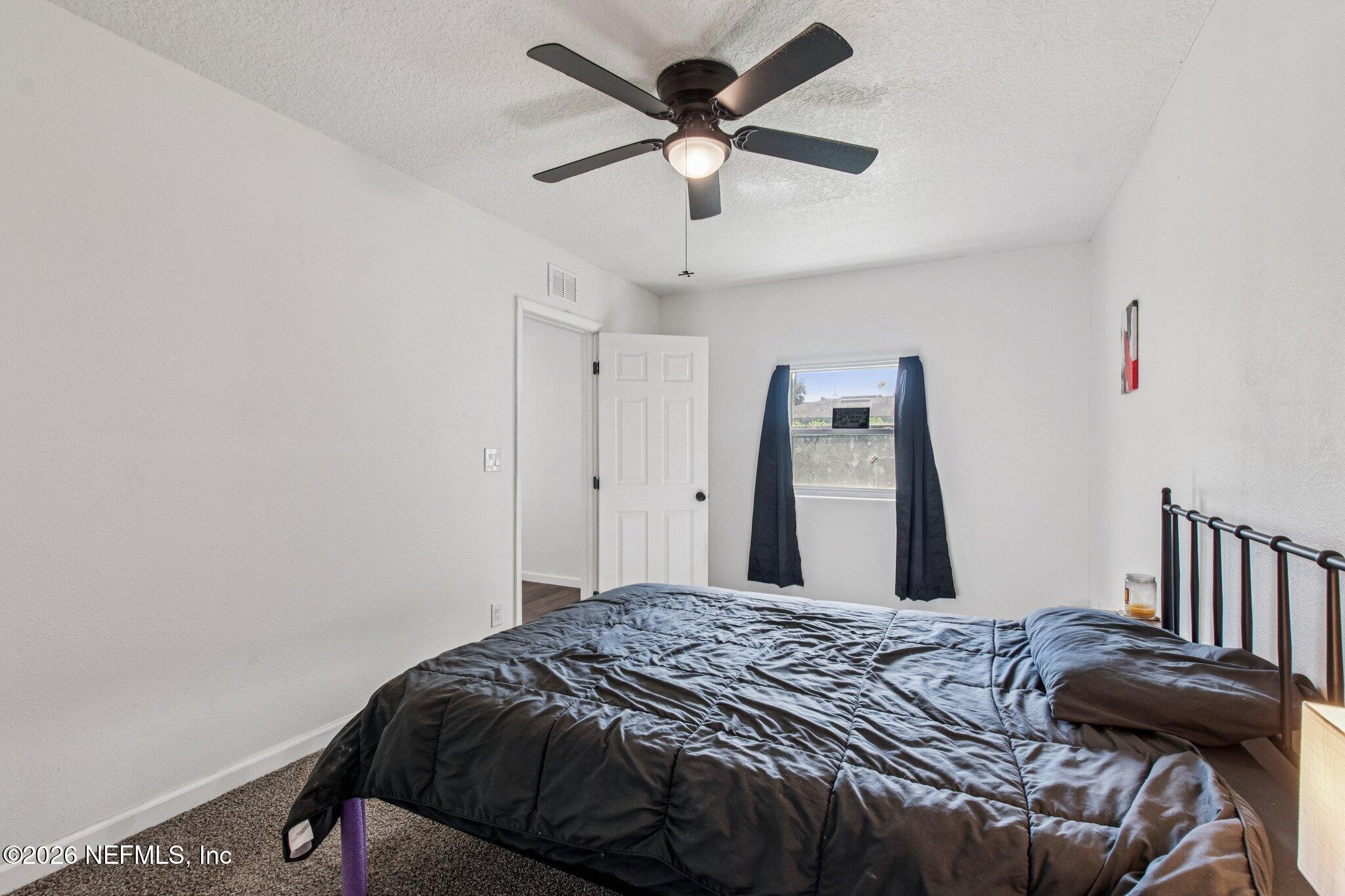 1417 Clock Street Jacksonville, FL 32211 - Photo 31 of 39 a bedroom with a bed and a chandelier