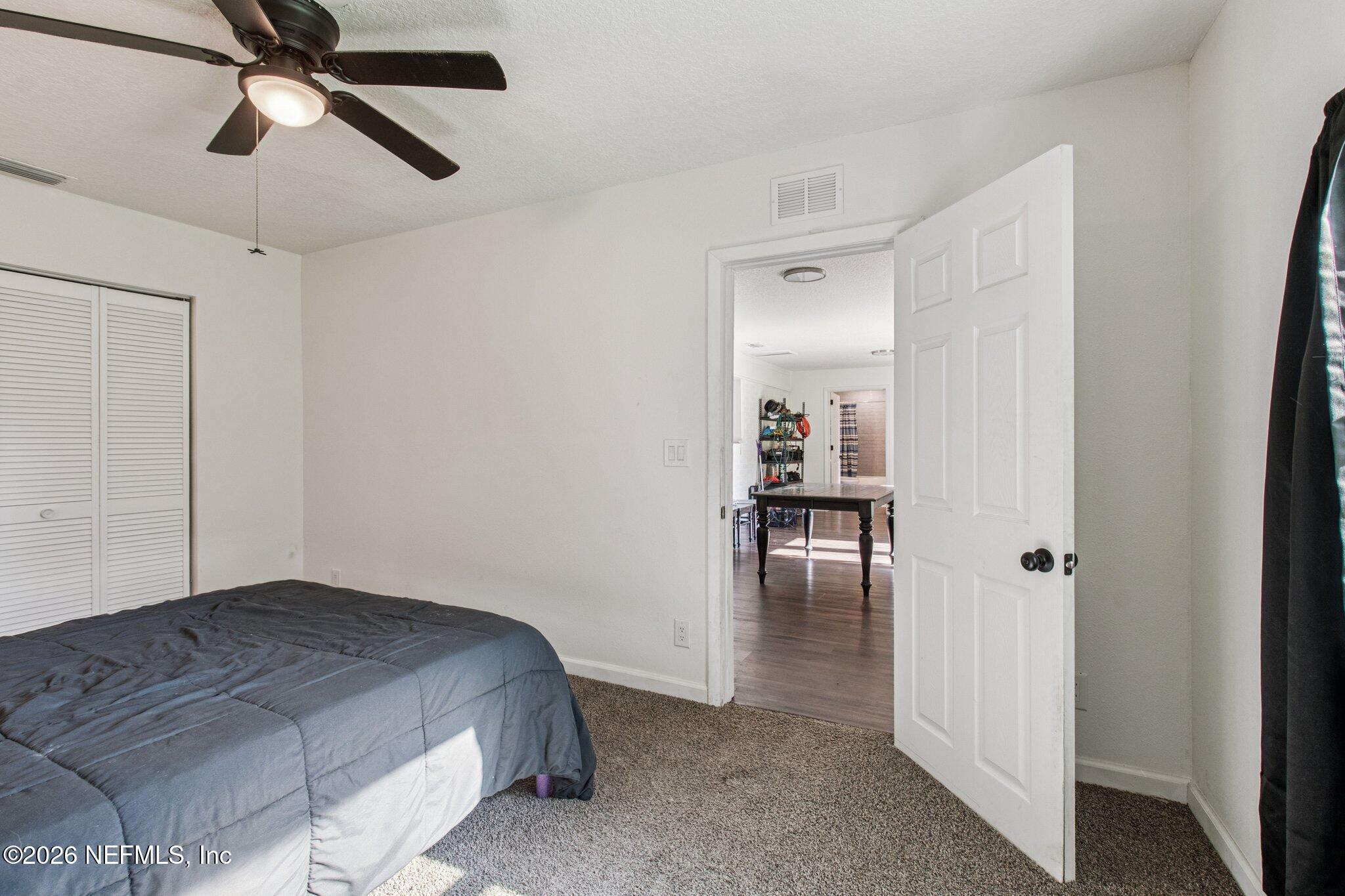 1417 Clock Street Jacksonville, FL 32211 - Photo 32 of 39 a bedroom with a bed and a chandelier