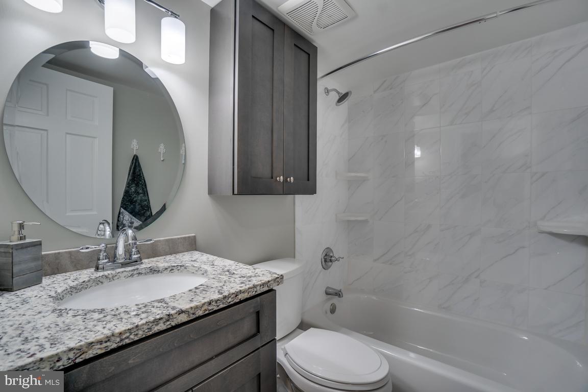 5811 Cambridge Drive, Unit 674 Springfield, VA 22152 - Photo 21 of 37 a bathroom with a granite countertop sink toilet and shower
