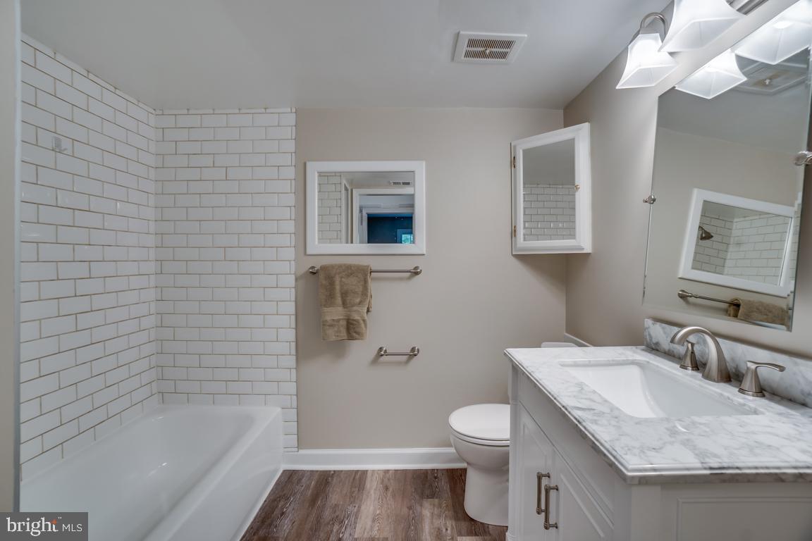 5811 Cambridge Drive, Unit 674 Springfield, VA 22152 - Photo 32 of 37 a bathroom with a granite countertop sink toilet and shower