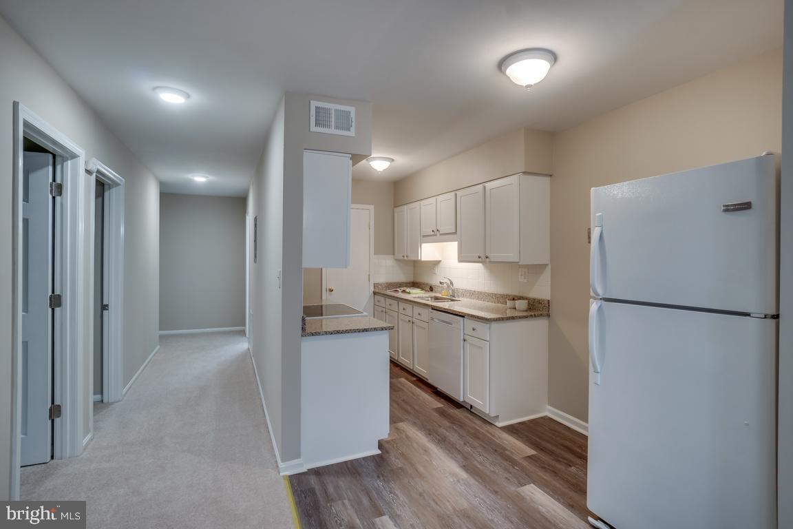 5811 Cambridge Drive, Unit 674 Springfield, VA 22152 - Photo 5 of 37 a kitchen with refrigerator a sink and white cabinets