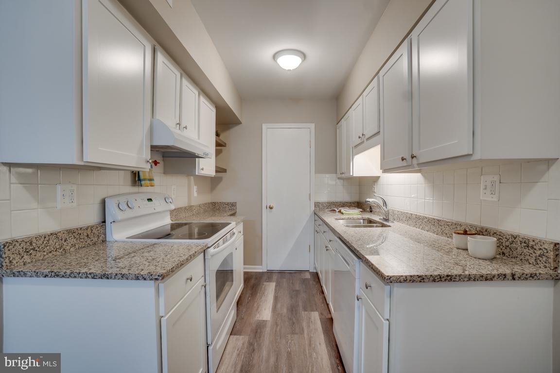 5811 Cambridge Drive, Unit 674 Springfield, VA 22152 - Photo 6 of 37 a kitchen with granite countertop stainless steel appliances a sink stove and cabinets