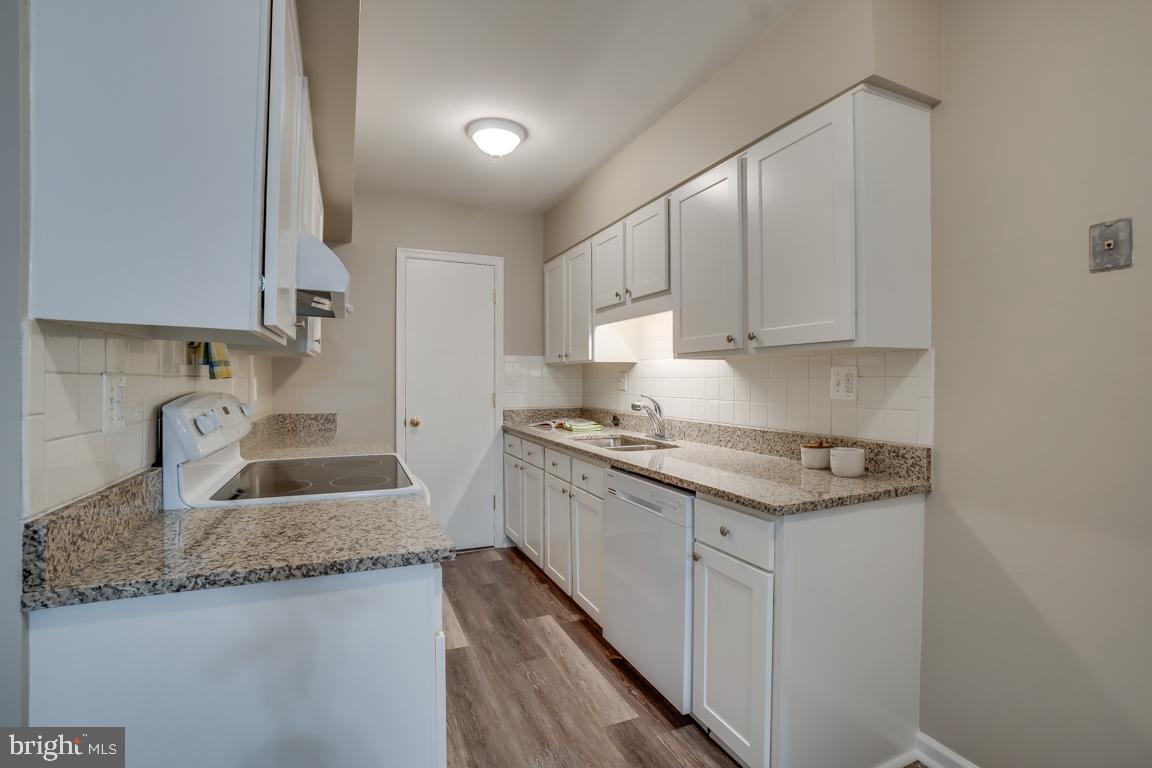 5811 Cambridge Drive, Unit 674 Springfield, VA 22152 - Photo 7 of 37 a kitchen with granite countertop a sink stove and cabinets