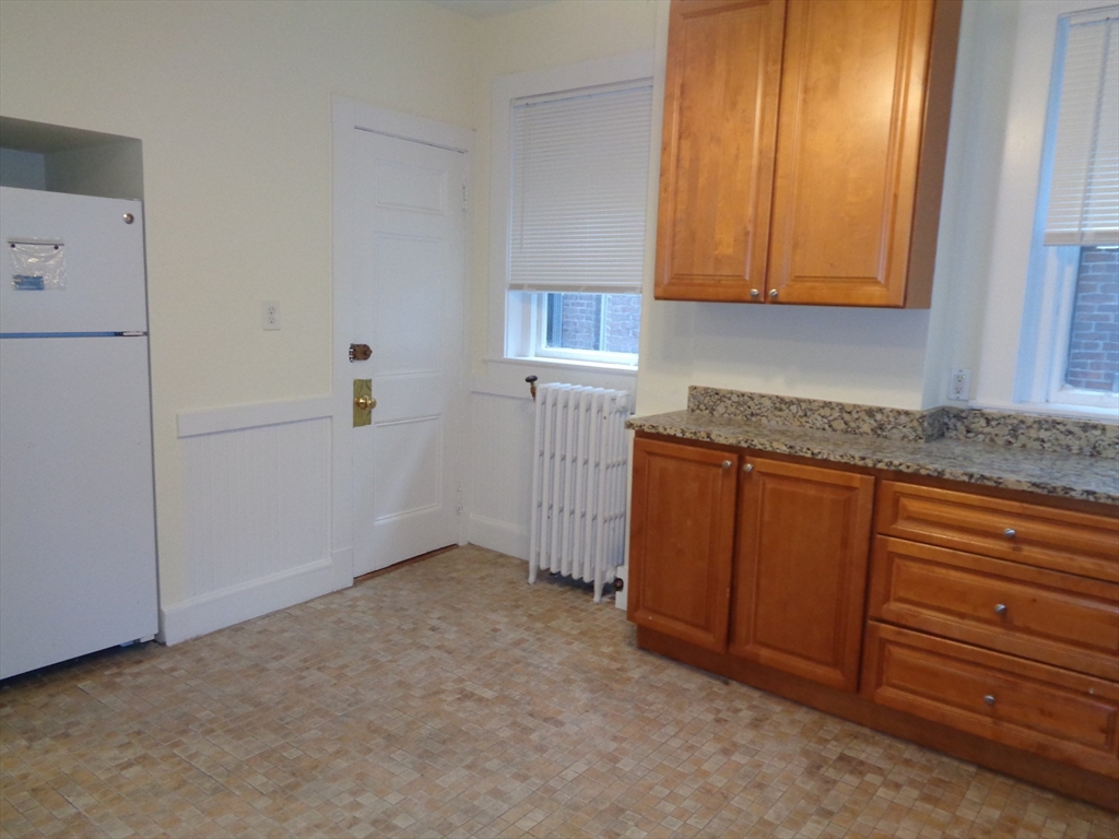 6 Beals Street, Unit 2 Brookline, MA 02446 - Photo 8 of 9 a kitchen with granite countertop cabinets and sink
