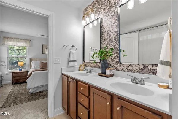 a en suite bathroom with a double vanity sink and a mirror