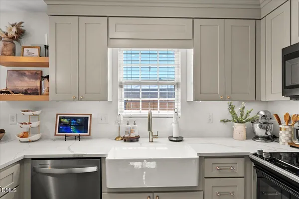 a kitchen with granite countertop a sink a stove and cabinets