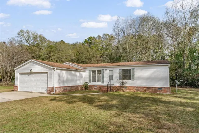 a front view of a house with a yard and trees