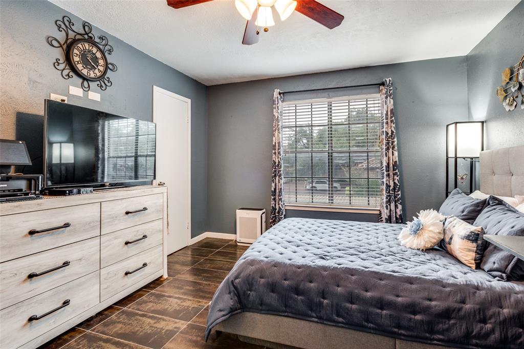 5626 Preston Oaks Road, Unit 31B Dallas, TX 75254 - Photo 8 of 17 a bedroom with a large bed and a flat tv screen on dresser