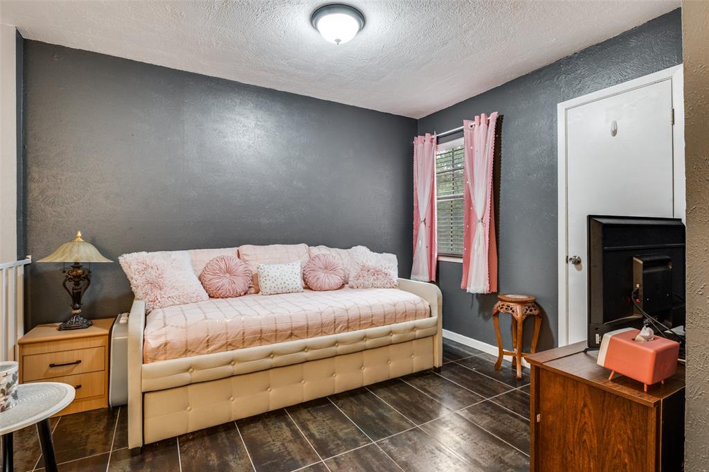5626 Preston Oaks Road, Unit 31B Dallas, TX 75254 - Photo 10 of 17 a bedroom with a bed and wooden floor